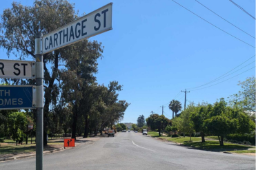 Carthage street sign in foreground with street in background