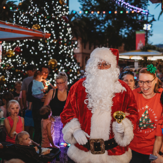 Santa arriving at the 2023 Lighting of the Christmas Tree event. He's surrounded by children